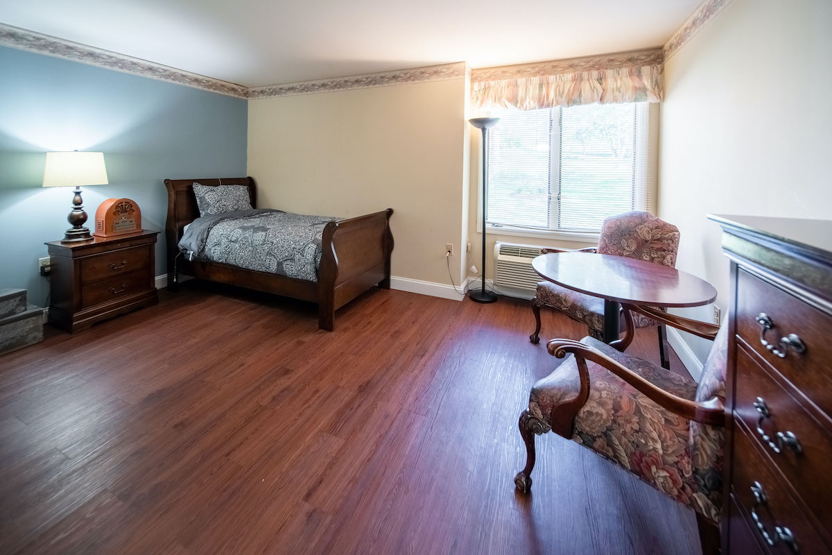 Bedroom with sitting area and hardwood floors